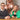 To celebrate, the entrepreneurs sit around the table with a smile on their faces. Big rose gold balloons float in the background.