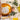 A child smiles happily from behind a ball of lion foil at a children's party with a colourful party tablecloth.