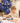 He smiles at her at the dinner table. The table is set with space-themed dishes and decorations. It's a children's birthday party with a space theme. 