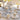 Beige floral-patterned paper plates with gold accents on the festive table.